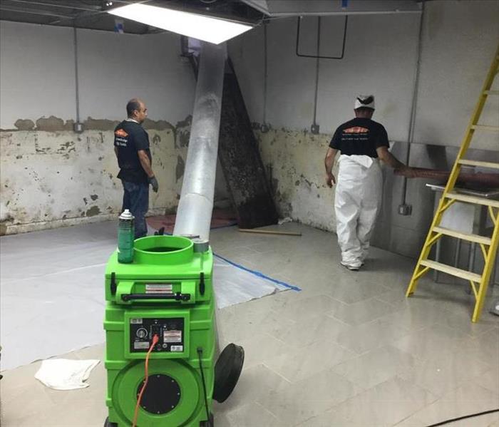 2 SERVPRO members in action removing damaged wall.
