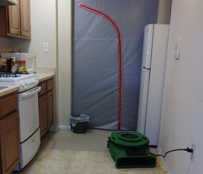 a tarp containment set up in between a doorway in a home